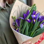 Маленькое фото 2: Букет из 7 фиолетовых ирисов с зеленью в крафте