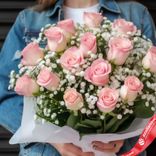 Маленькое фото 2: Букет из 15 розовых роз и гипсофил в белой бумаге