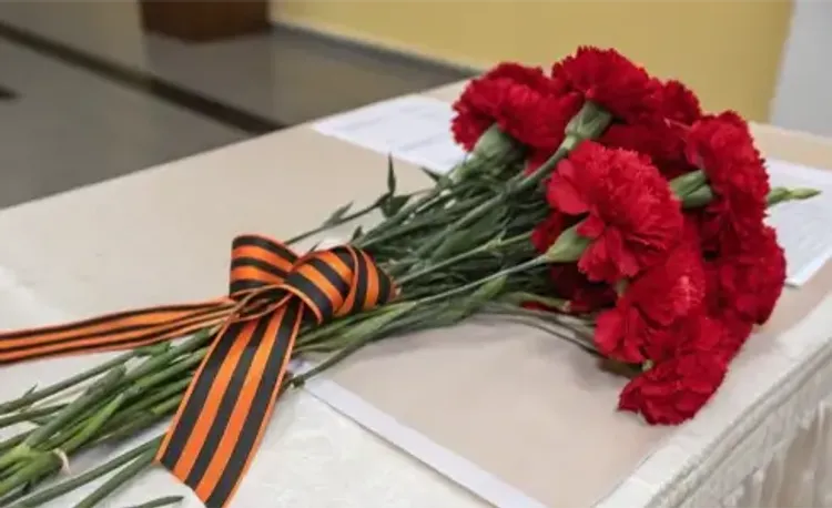Букет гвоздик с Георгиевской лентой на столе