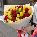 Маленькое фото 1: Букет из 17 желтых тюльпанов и 12 красных гвоздик в белой бумаге с лентой