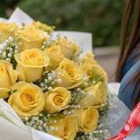 Маленькое фото 3: Букет из 15 желтых роз и гипсофил в белой бумаге
