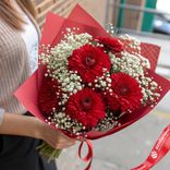Маленькое фото 1: Яркий букет из 5 красных георгин с гипсофилой в красной упаковке «Рубиновый блеск»