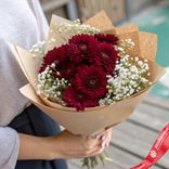 Маленькое фото 1: Букет из 7 бордовых хризантем и гипсофилы в крафте «Тепло сердец»
