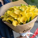 Маленькое фото 2: Букет 25 желтых калл в крафте, с белой лентой
