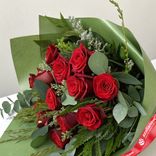 Маленькое фото 2: Траурный букет из 12 красных роз в зеленой бумаге