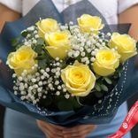 Маленькое фото 2: Букет из 7 желтых роз и 4 белых гипсофил в синей упаковке