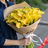 Маленькое фото 1: Букет 25 желтых калл в крафте, с белой лентой